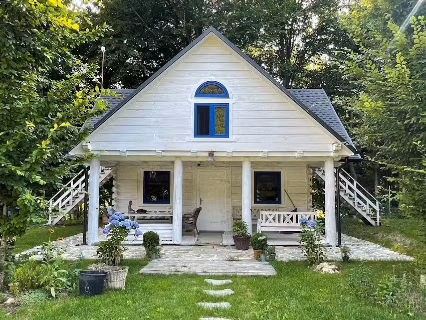 Ein weißes Häuschen im Wald in Roztocze